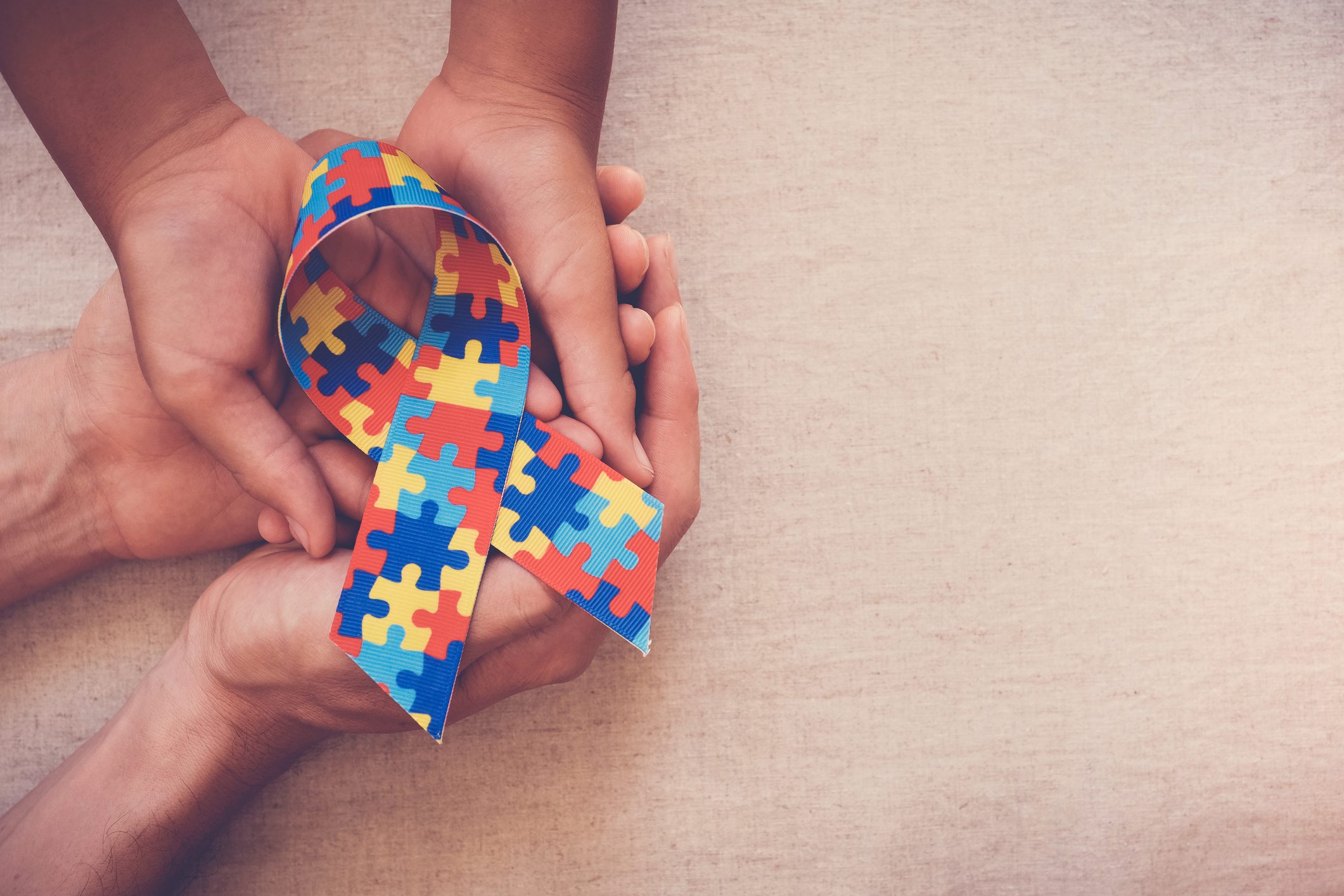 Manos sosteniendo la cinta del rompecabezas para la conciencia del autismo
