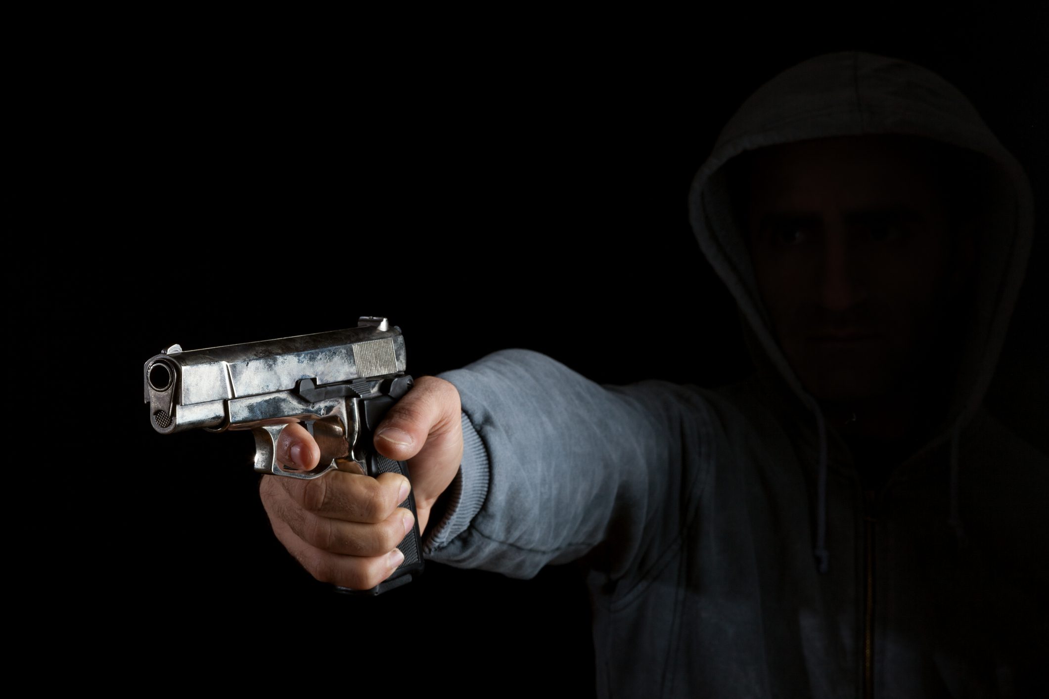 Adult Gunman Aiming Handgun In Dark