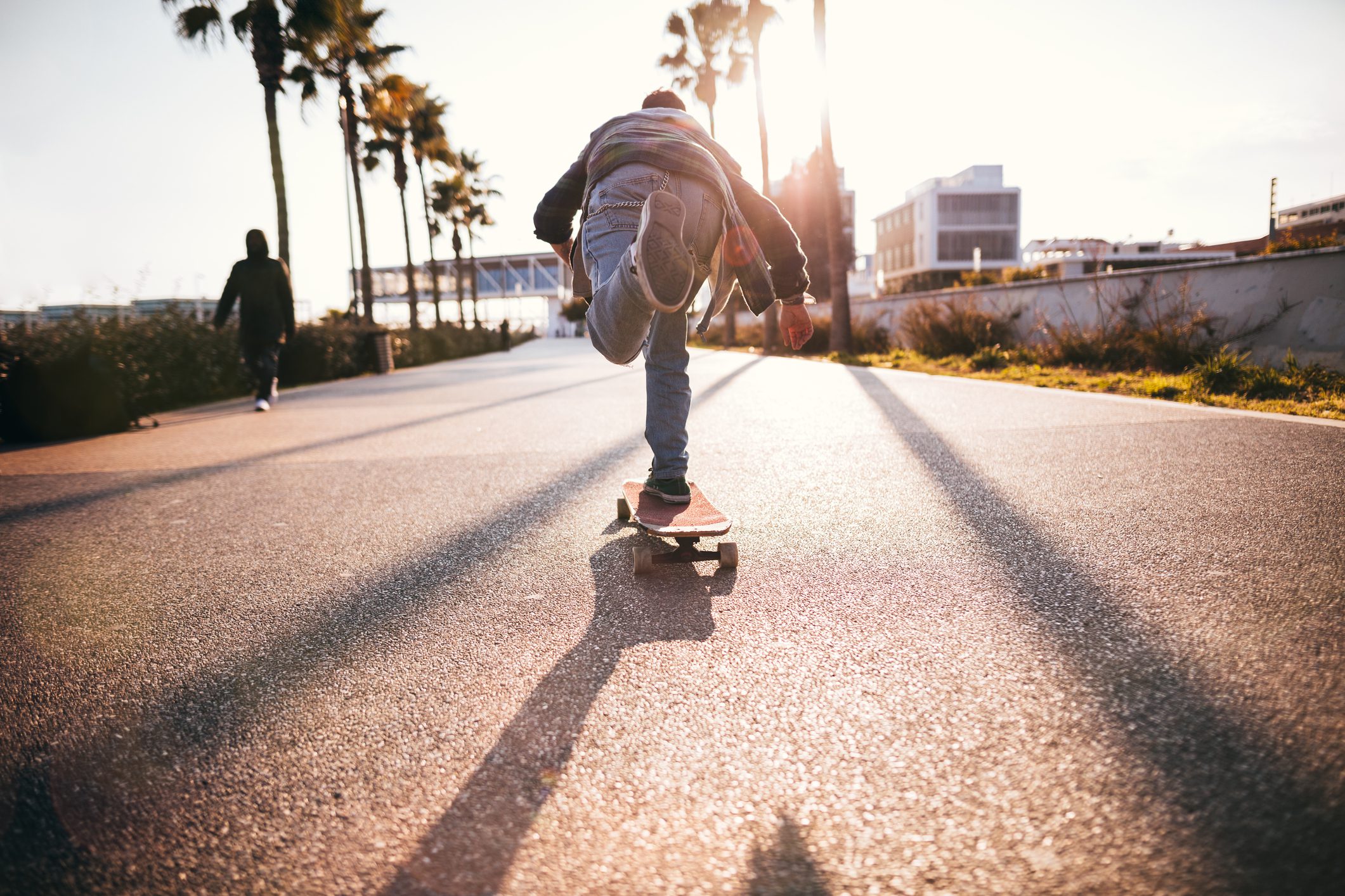 Cool teenage boy skateboarding in urban park as a hobby