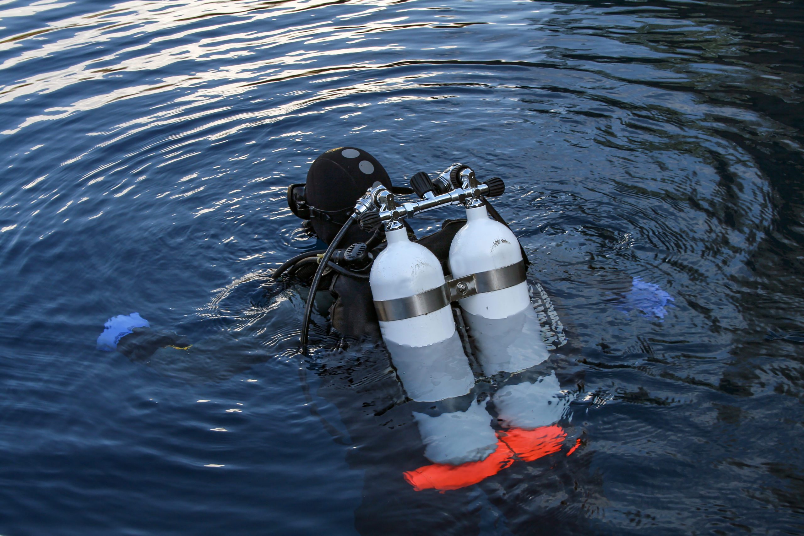 Diver plunges into the dark water deep lake