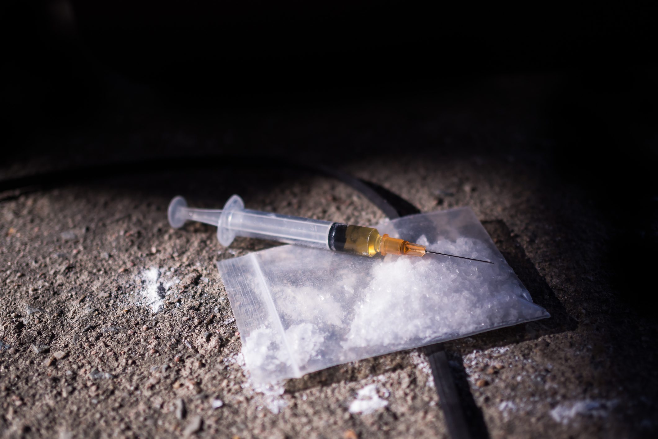 Amphetamine and syringe on black background. Substance abuse concept.copy space.