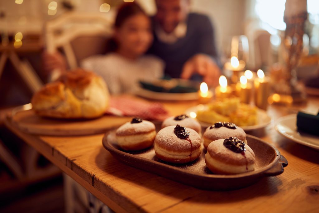 Sufganiyah, jam filled donuts on dining table during Hanukkah celebration.