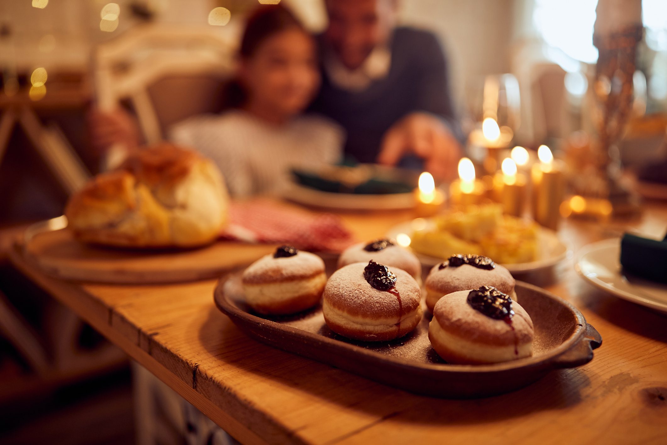 Sufganiyah, jam filled donuts on dining table during Hanukkah celebration.