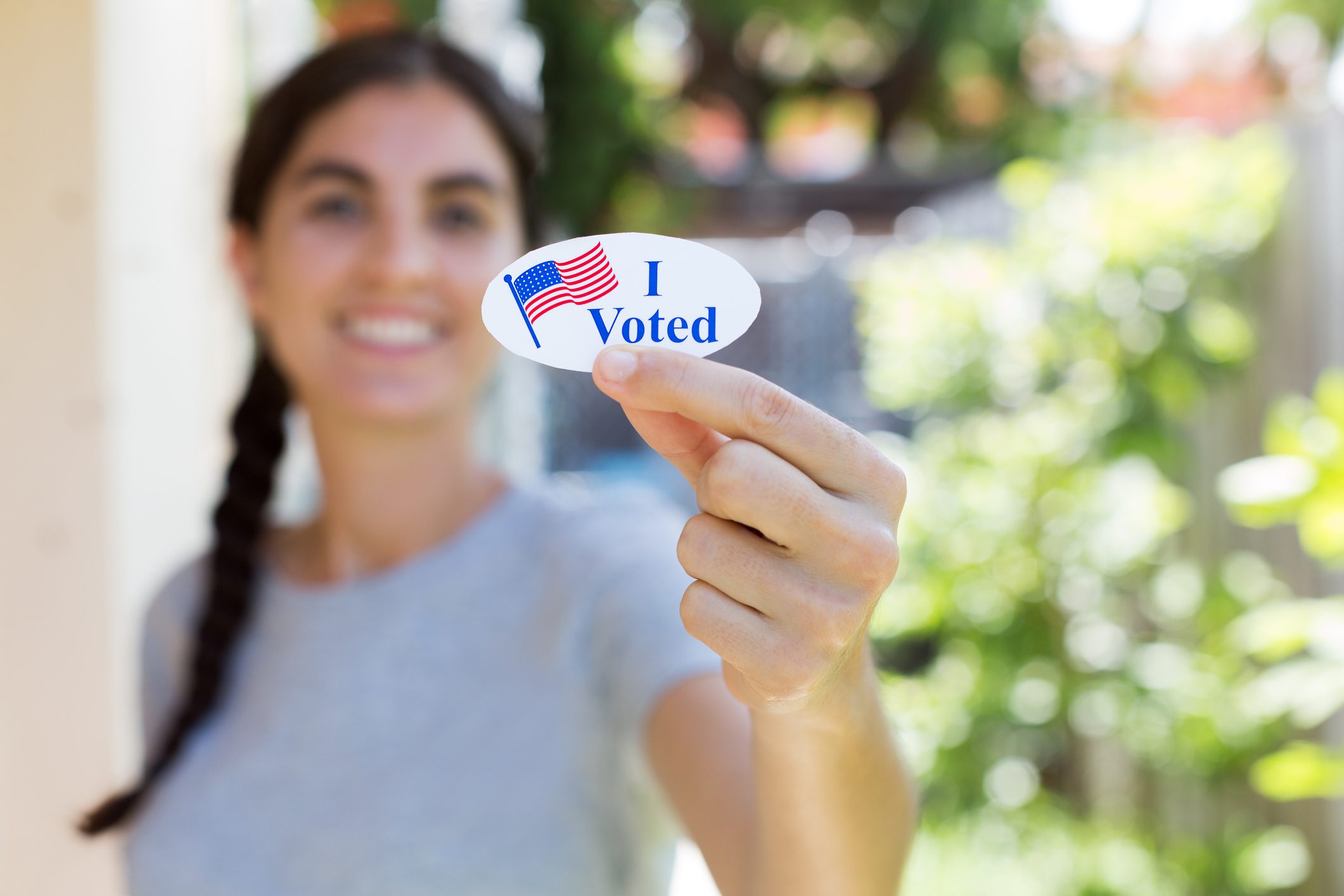Young woman holding I voted sticker