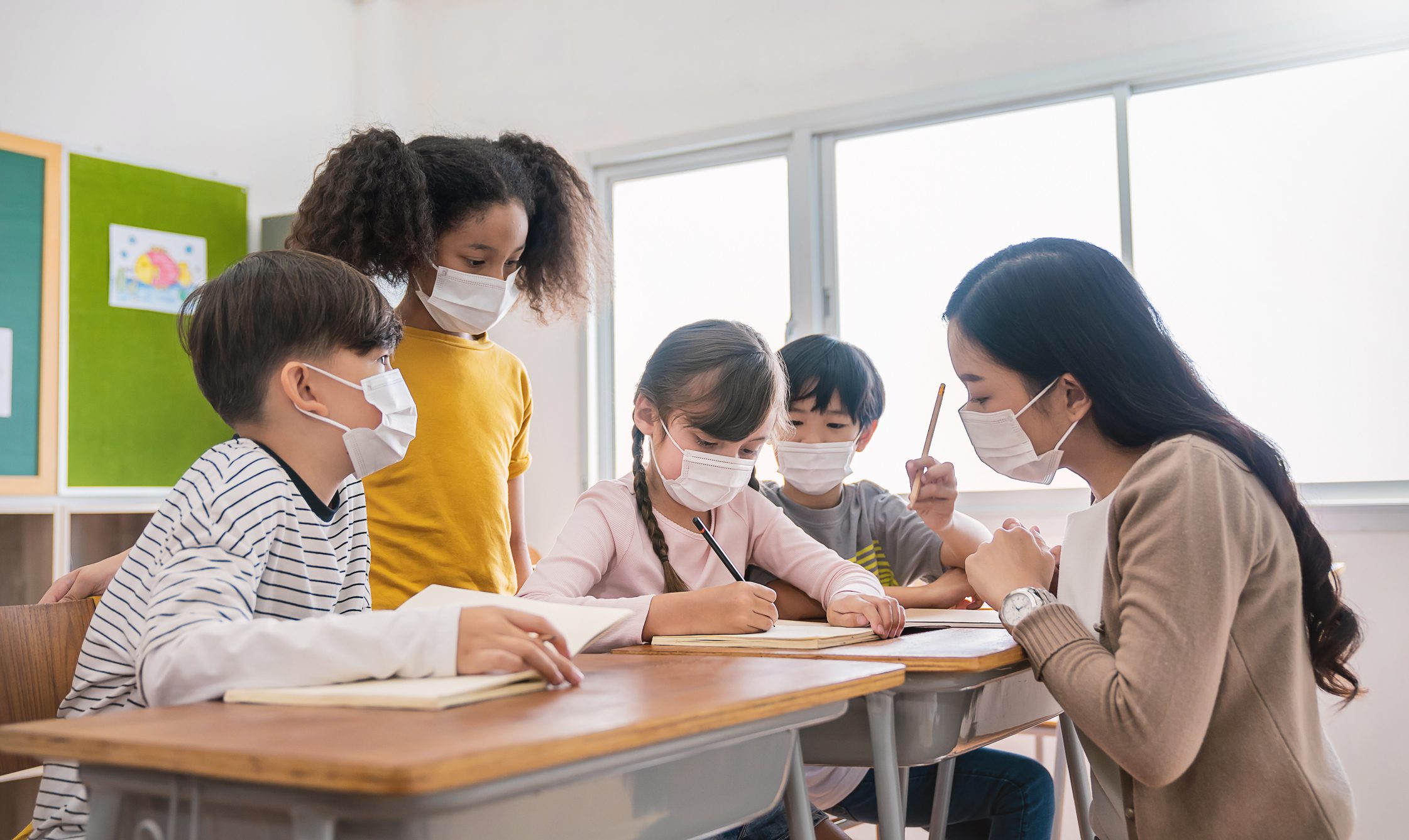 Portrait of international caucasian and asian students teacher wearing face mask in group study, self-protect from corona virus after lockdown. New normal, back to school concept
