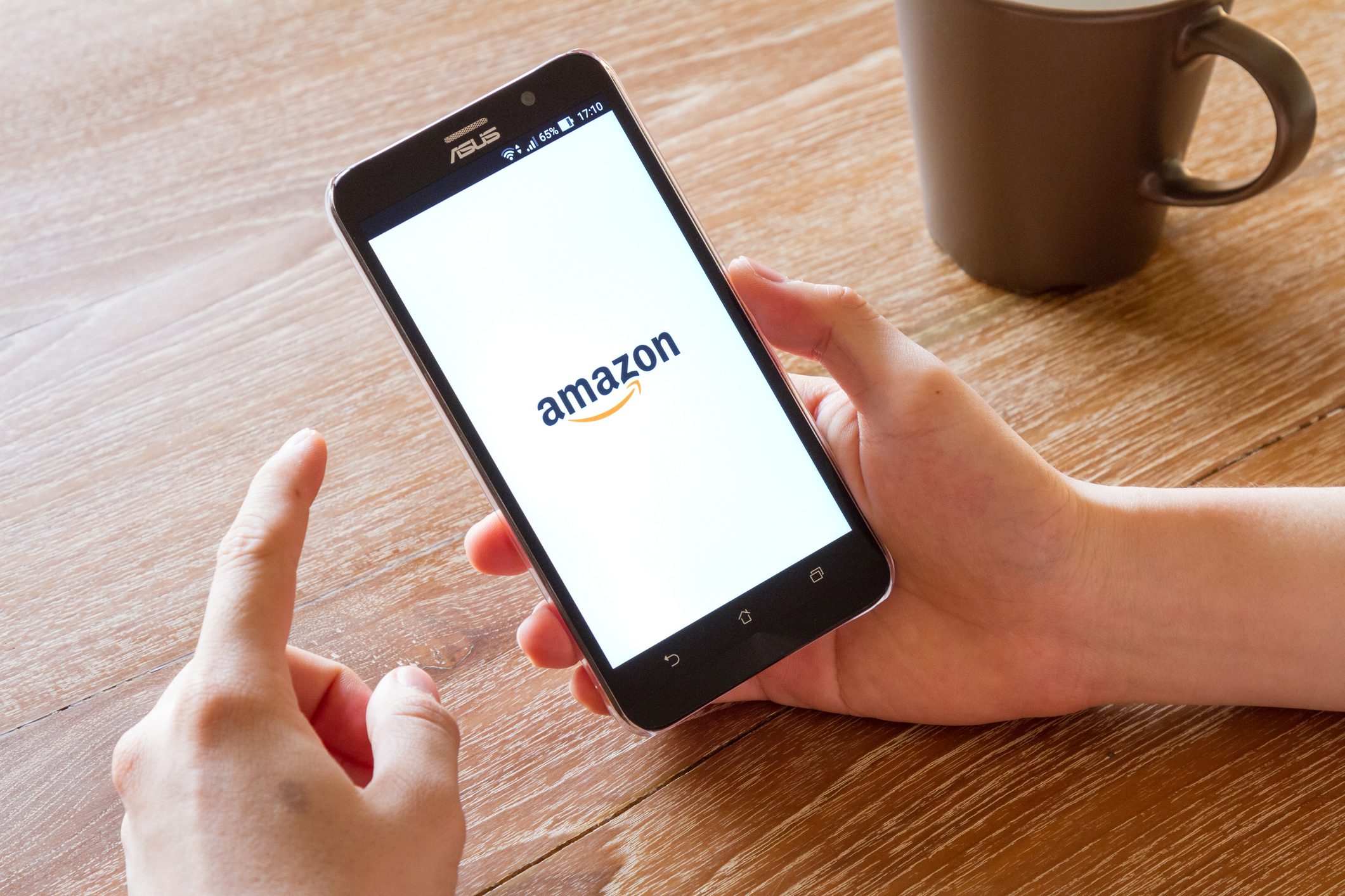 man hand holding screen shot of Amazon application