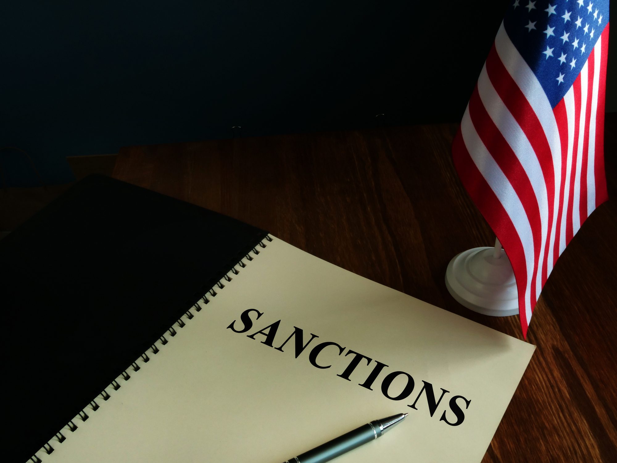 American sanctions and USA flag on table.