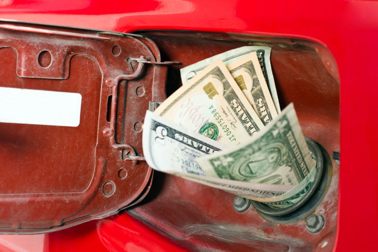 Money in a gas tank symbolizing high gas prices. | image from twity1