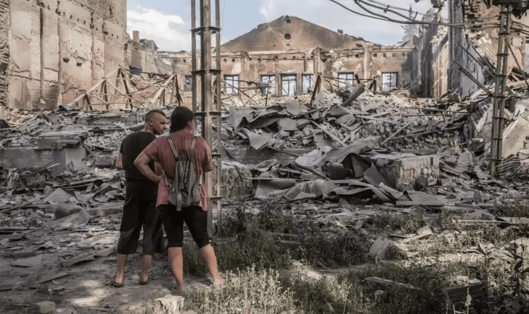 Local people surveying destroyed buildings in Lysychansk