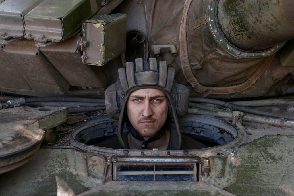 Ukrainian serviceman peers out of a tank in the Donetsk region, where Russia has seized towns.