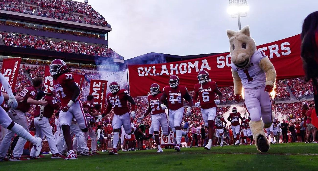 Oklahoma Sooners football players running onto field