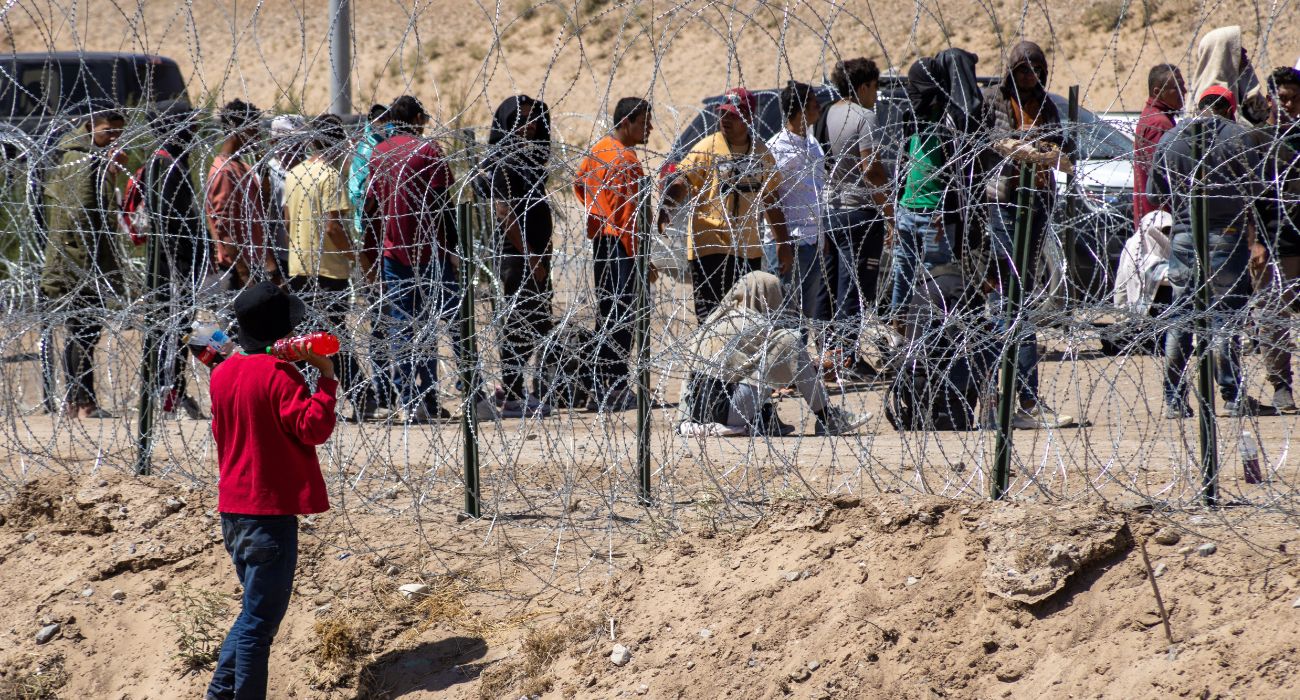 Migrants along the border wall