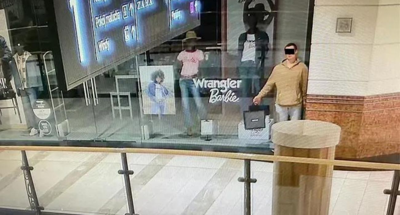 man posed in a mall store window