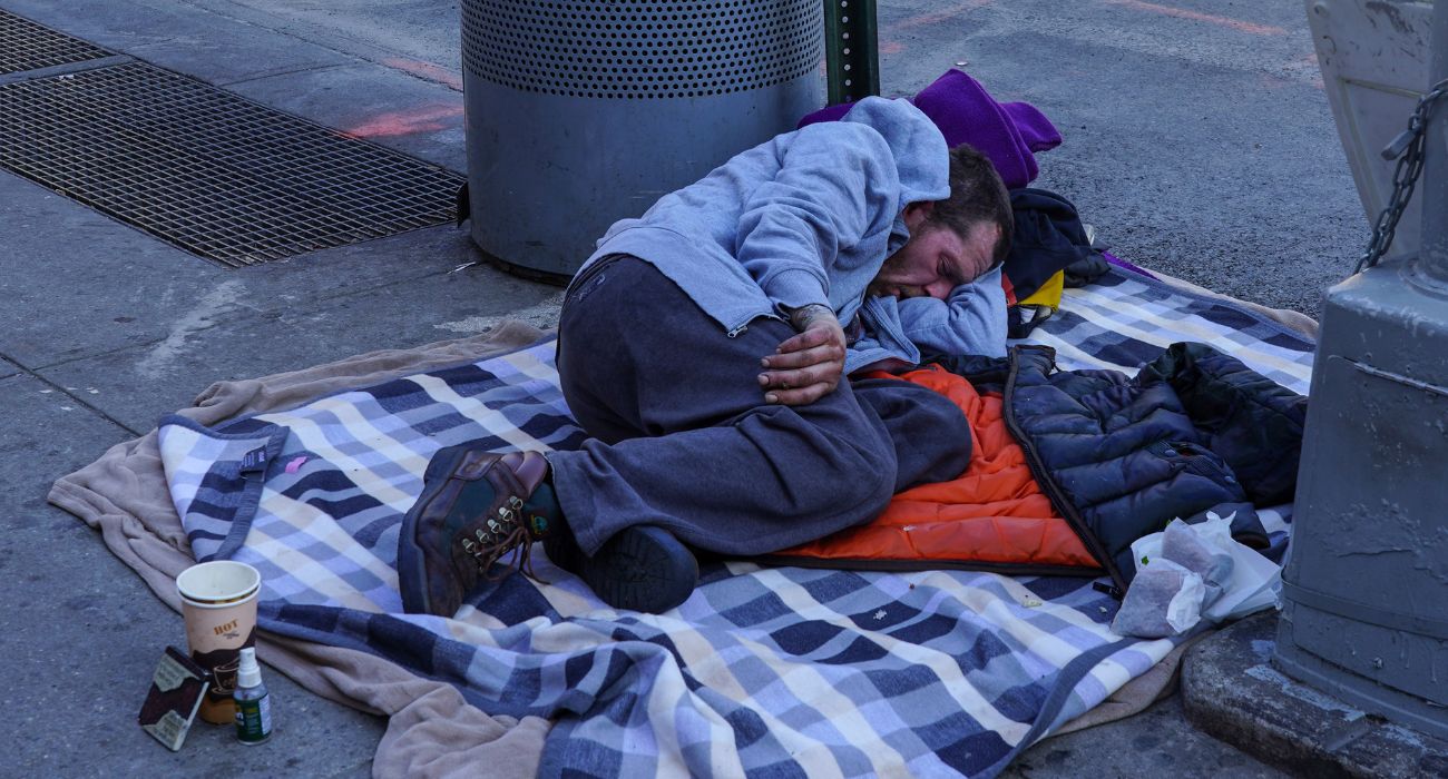 Homeless man sleeping on a sidewalk