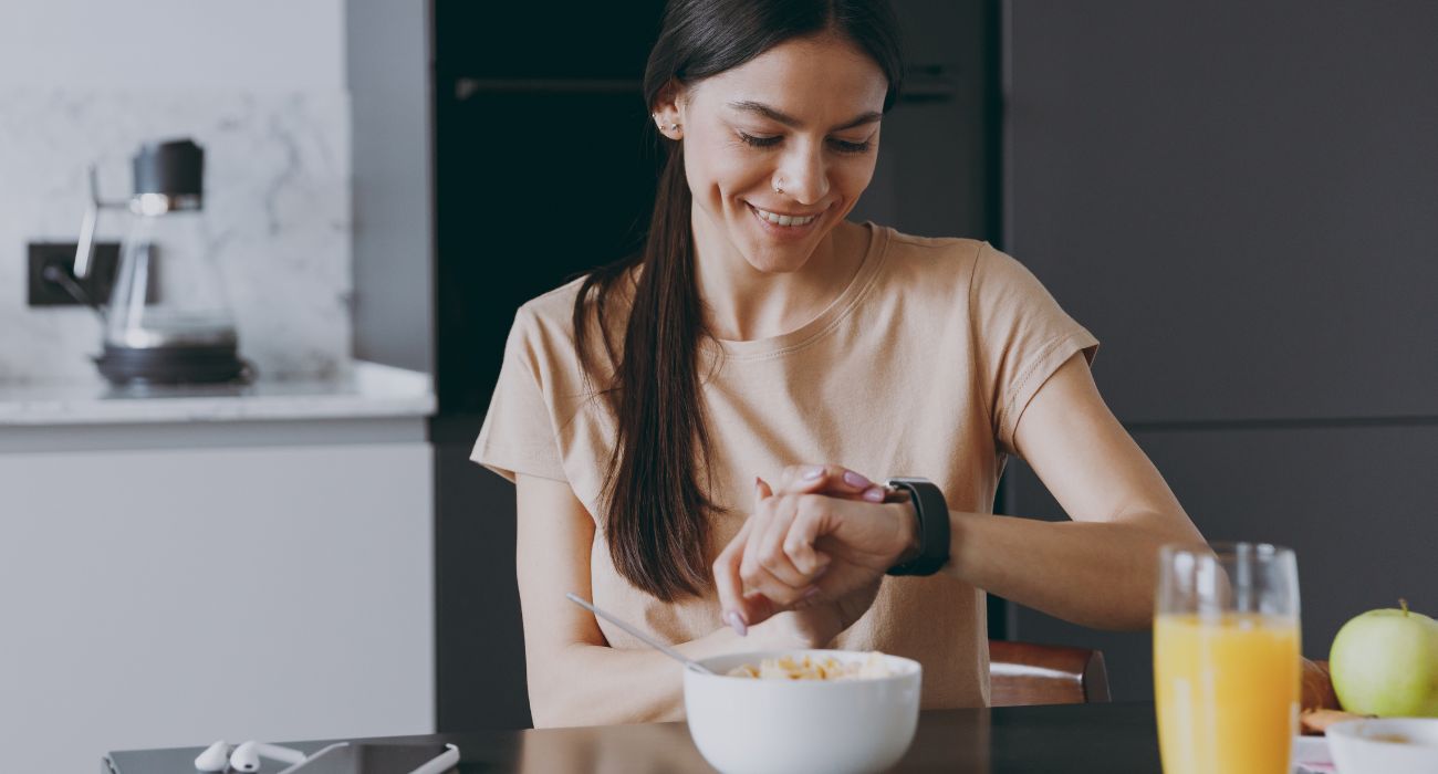 Woman eating breakfast while checking her watch