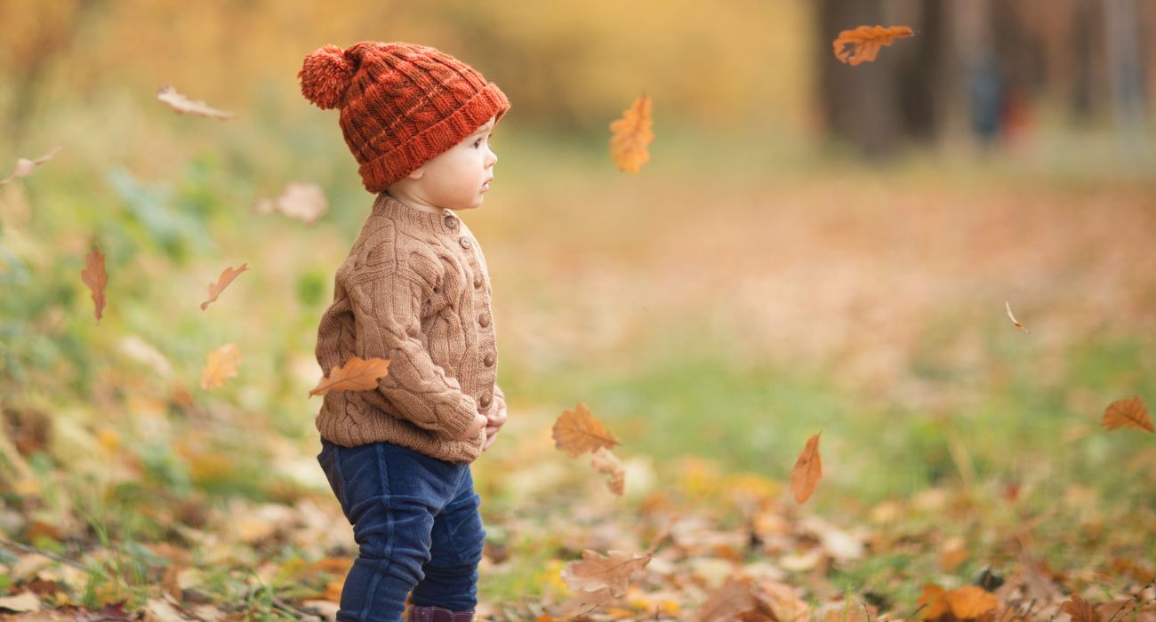 Child plays outside on a fall day