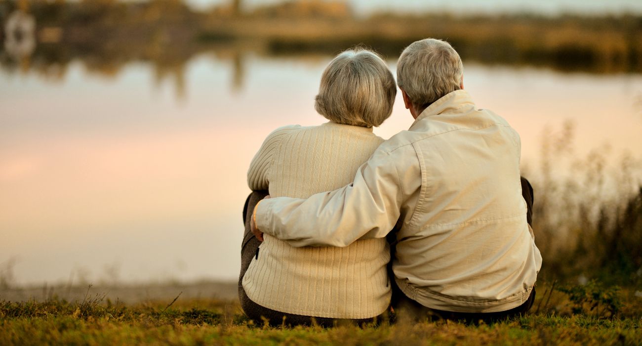 Senior couple sitting near lake.