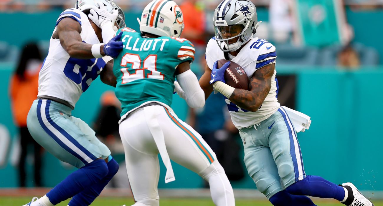 Tony Pollard #20 of the Dallas Cowboys runs the ball while defended by DeShon Elliott #21 of the Miami Dolphins on December 24, 2023 in Miami Gardens, Florida.