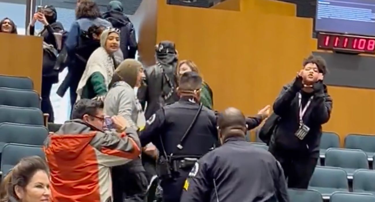 Screengrab from video of Anti-Israel protestors being escorted out of Dallas Council meeting by officers