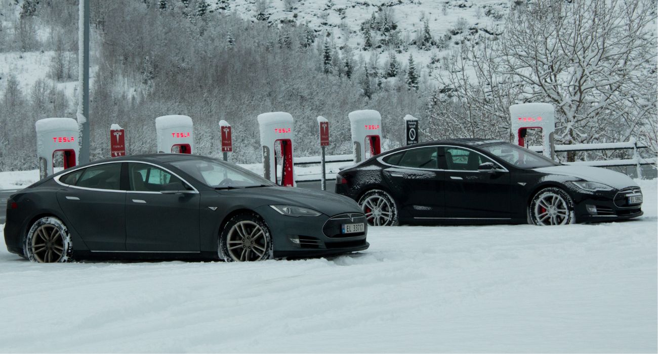 Teslas on charger in snow.