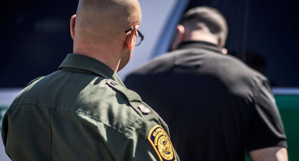 U.S. Customs and Border Protection agent detains an unlawful migrant