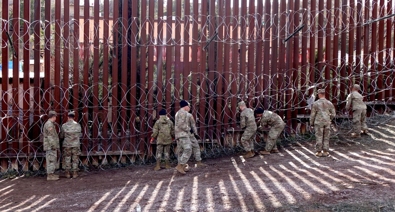 The National Guard attaches razor wire to the southern border wall.
