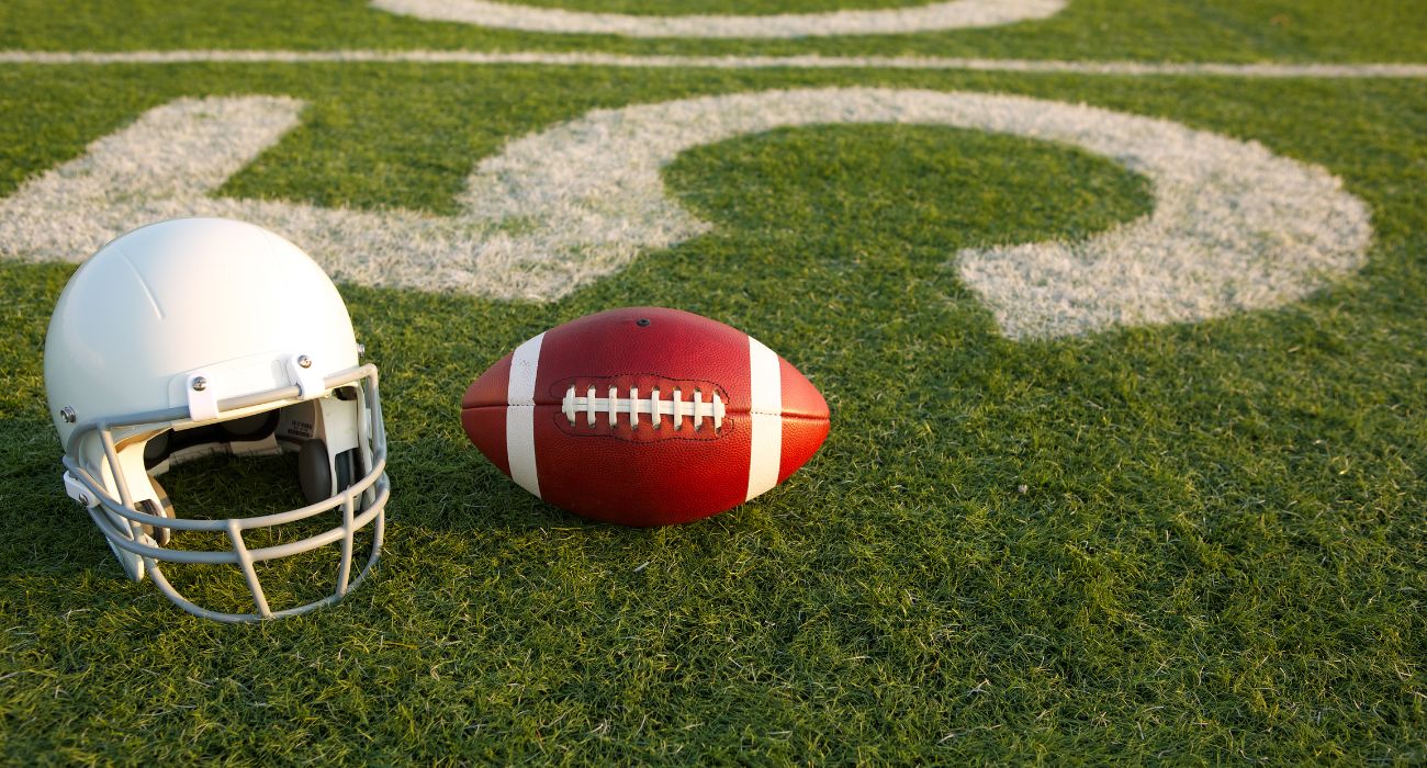 Football helmet and football on football field
