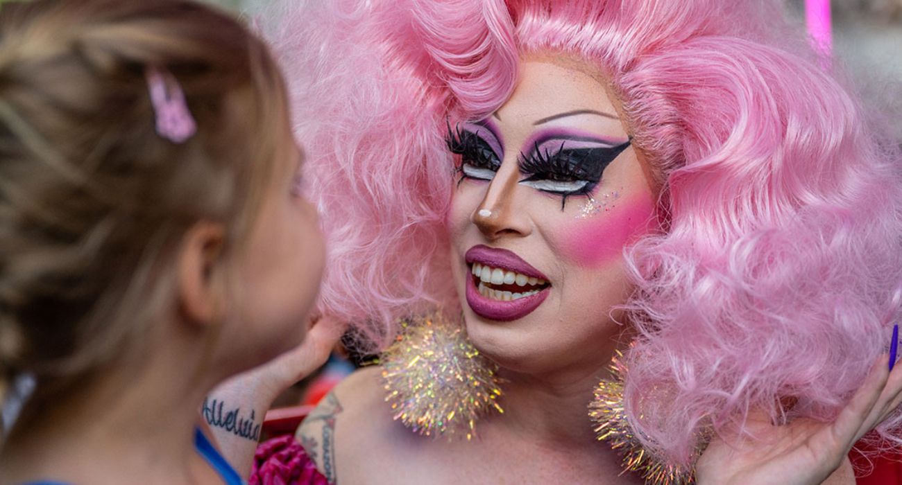 Drag queen Brigitte Bandit speaks with a child during a story time reading
