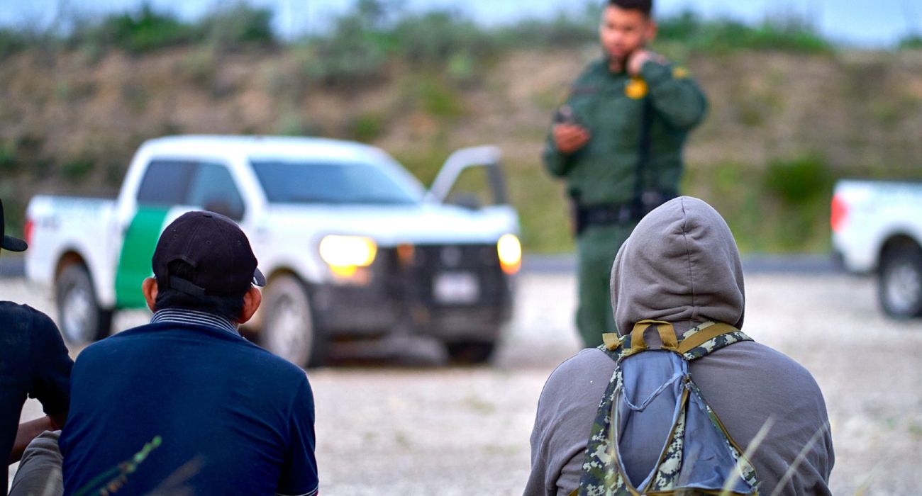 A U.S. Border Patrol agent checks unlawful migrants