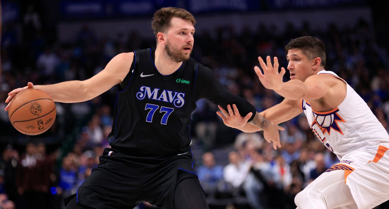 Luka Doncic #77 of the Dallas Mavericks handles the ball as Grayson Allen #8 of the Phoenix Suns defends.