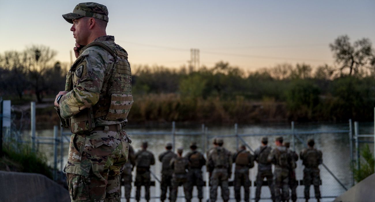 National Guard soldiers stand guard on the banks of the Rio Grande river
