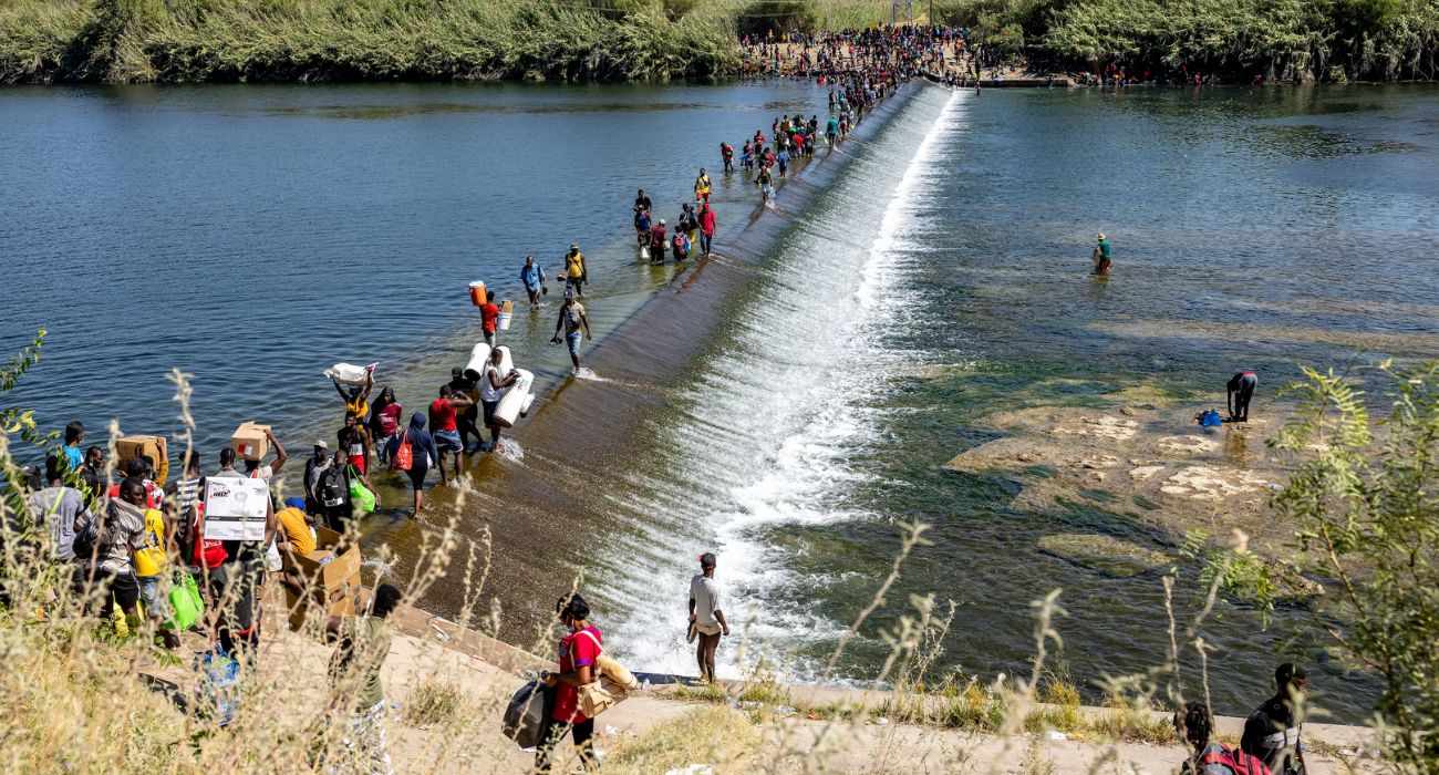 Unlawful migrants walk across the Rio Grande River