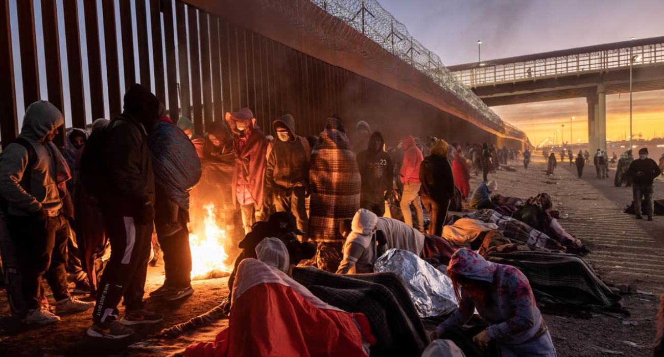Migrants keep warm by a fire