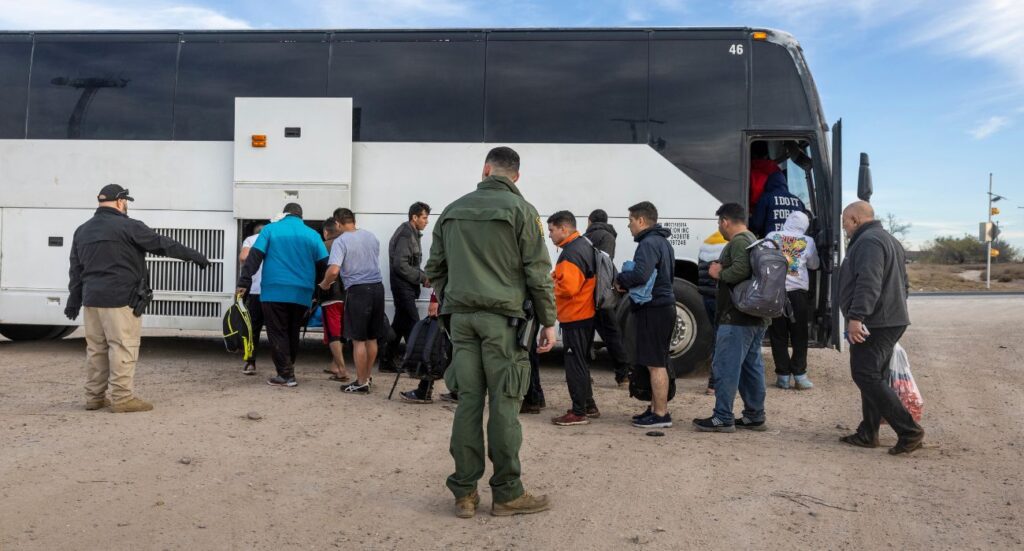 Unlawful migrants file into a U.S. Customs and Border Protection bus