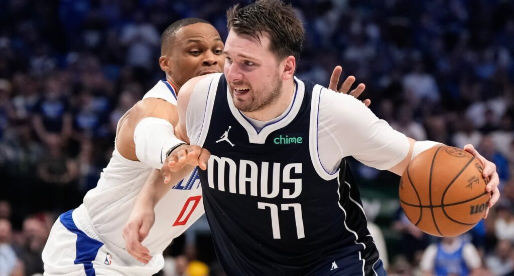 Luka Doncic #77 of the Dallas Mavericks is defended by Russell Westbrook #0 of the Los Angeles Clippers