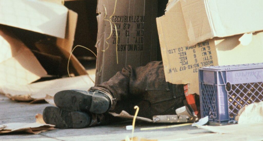 Homeless person sleeping in cardboard box