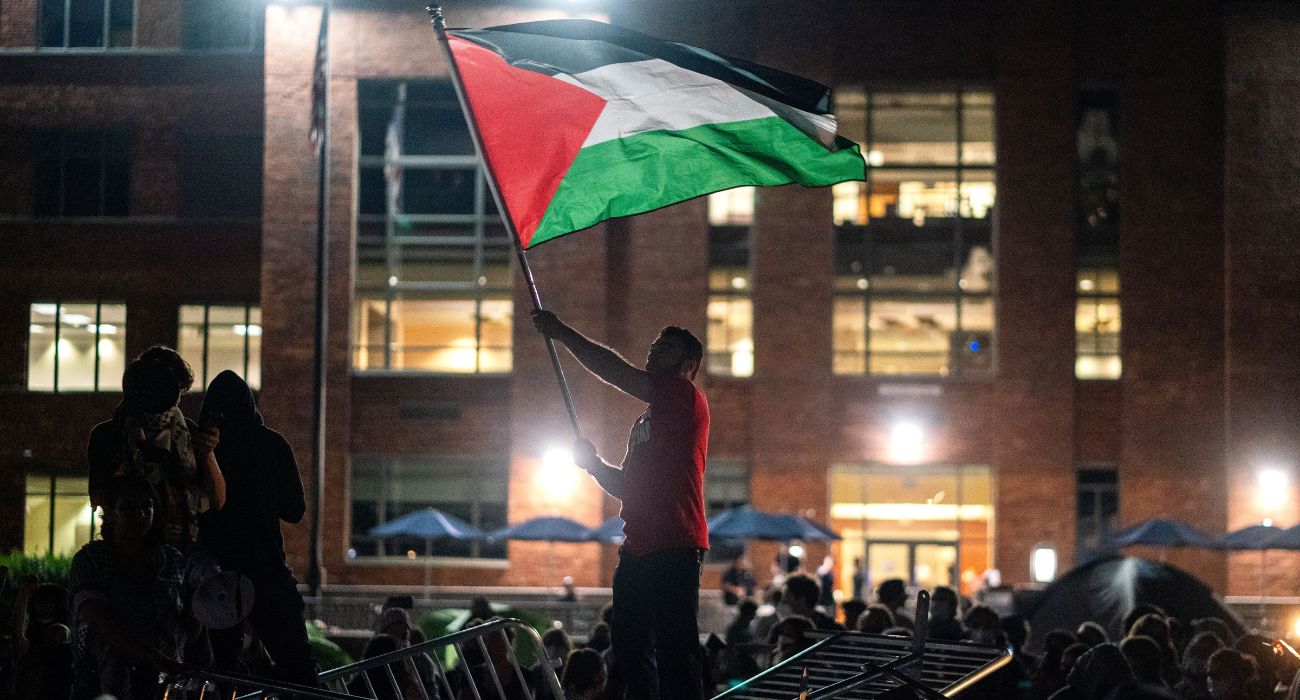 A man holds up a Palestinian flag