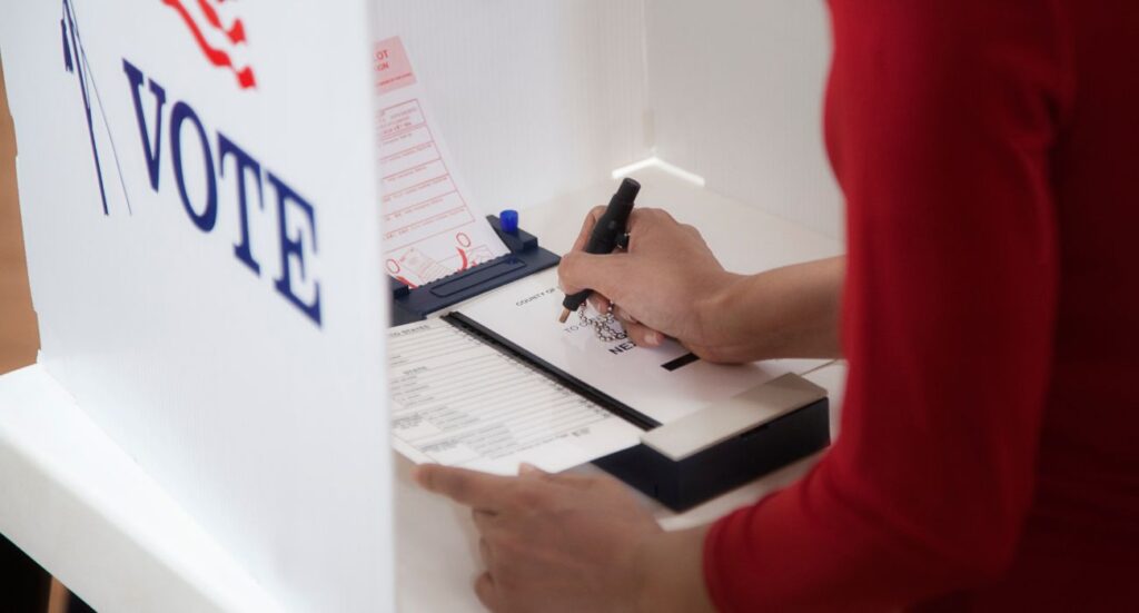 Person voting in booth | Image by Hill Street Studios/Getty Images