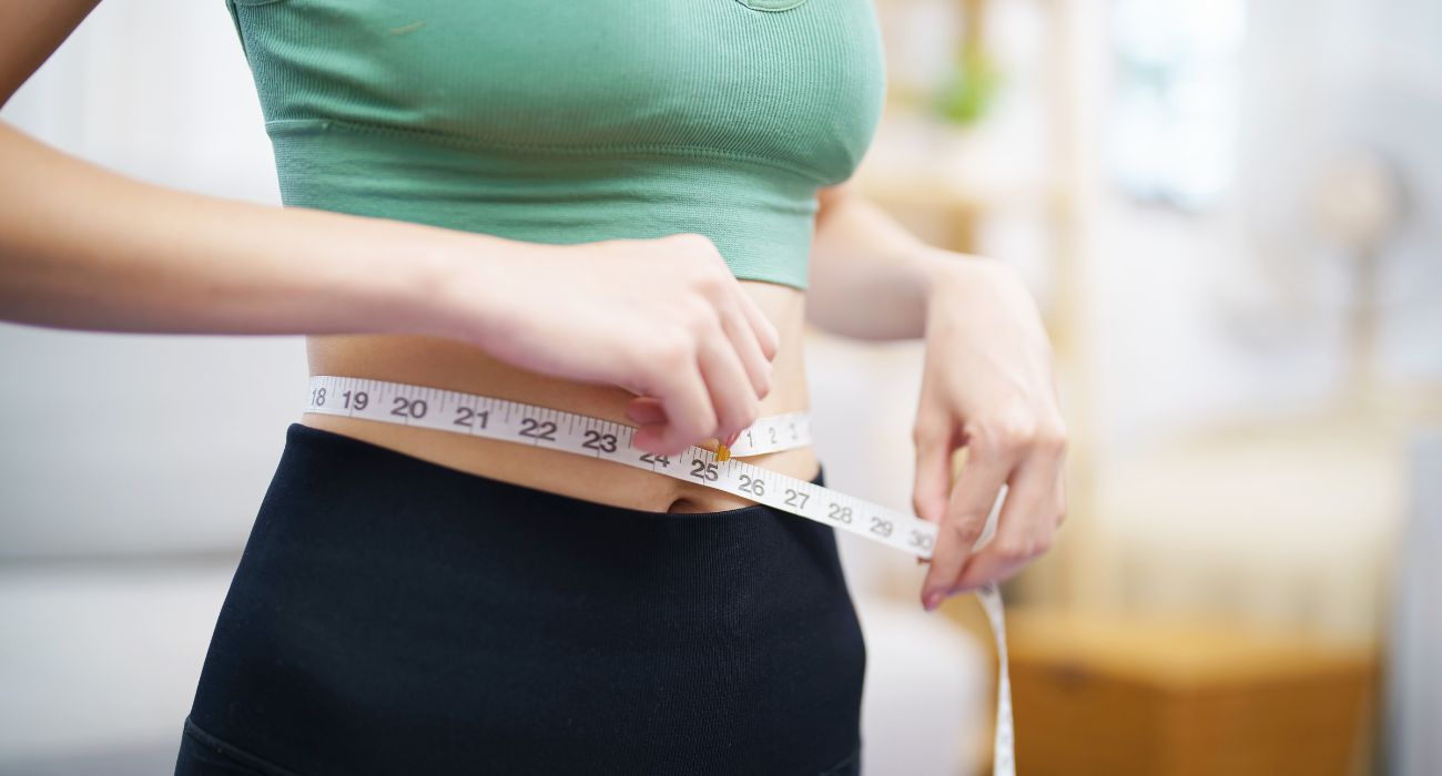 Woman measuring waist | Image by Lee Charlie/Shutterstock