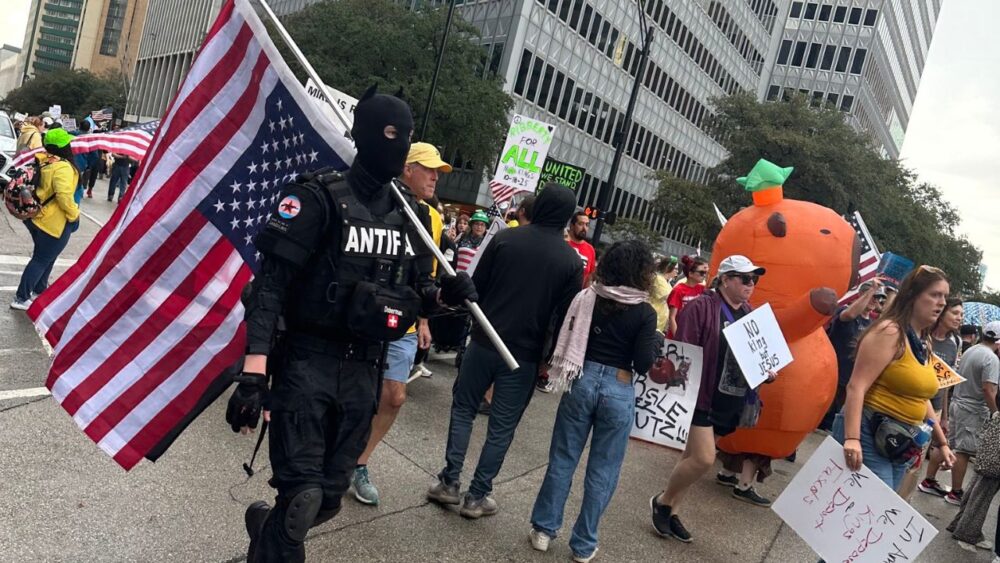 Antifa Member Identified At Dallas “No Kings” Rally, Waving Flag And Leading March